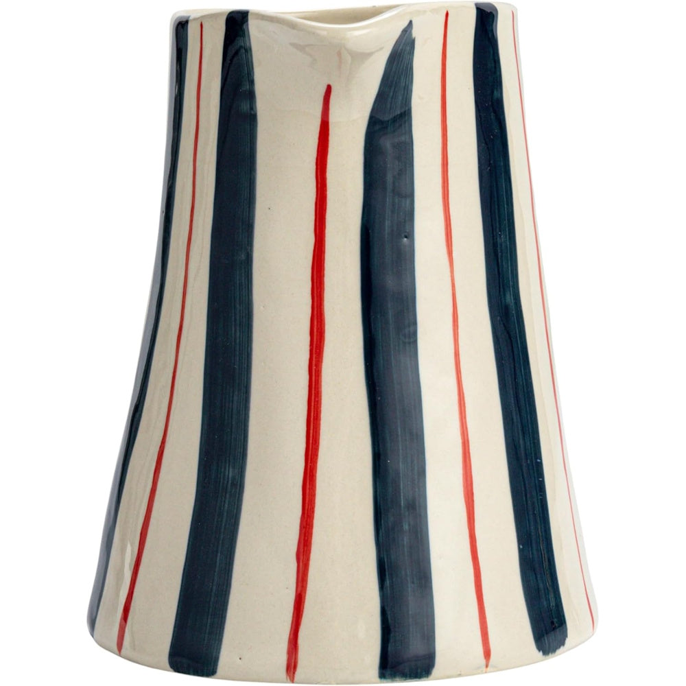 A hand-painted ceramic pitcher with vertical, uneven dark blue and thin red stripes on a cream background.