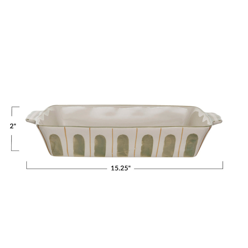 A hand-painted stoneware baking dish with green arched patterns, measuring 15.25 inches wide and 2 inches deep.