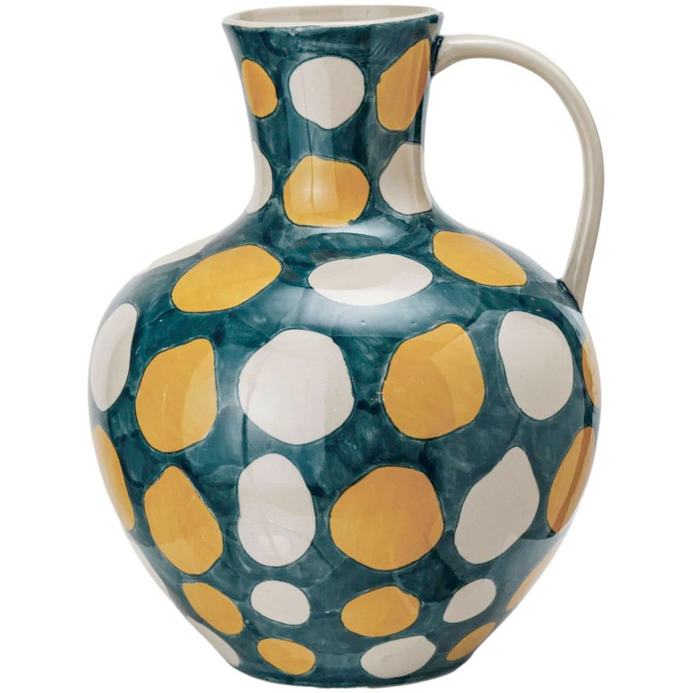 Hand-painted ceramic pitcher with yellow and white polka dots on a dark teal glaze.