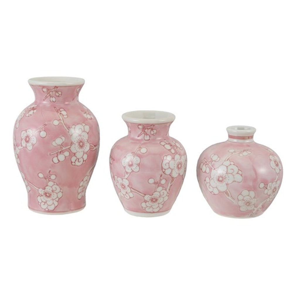 Three small, pink stoneware vases in various shapes, hand-painted with white cherry blossom branches on a white background.
