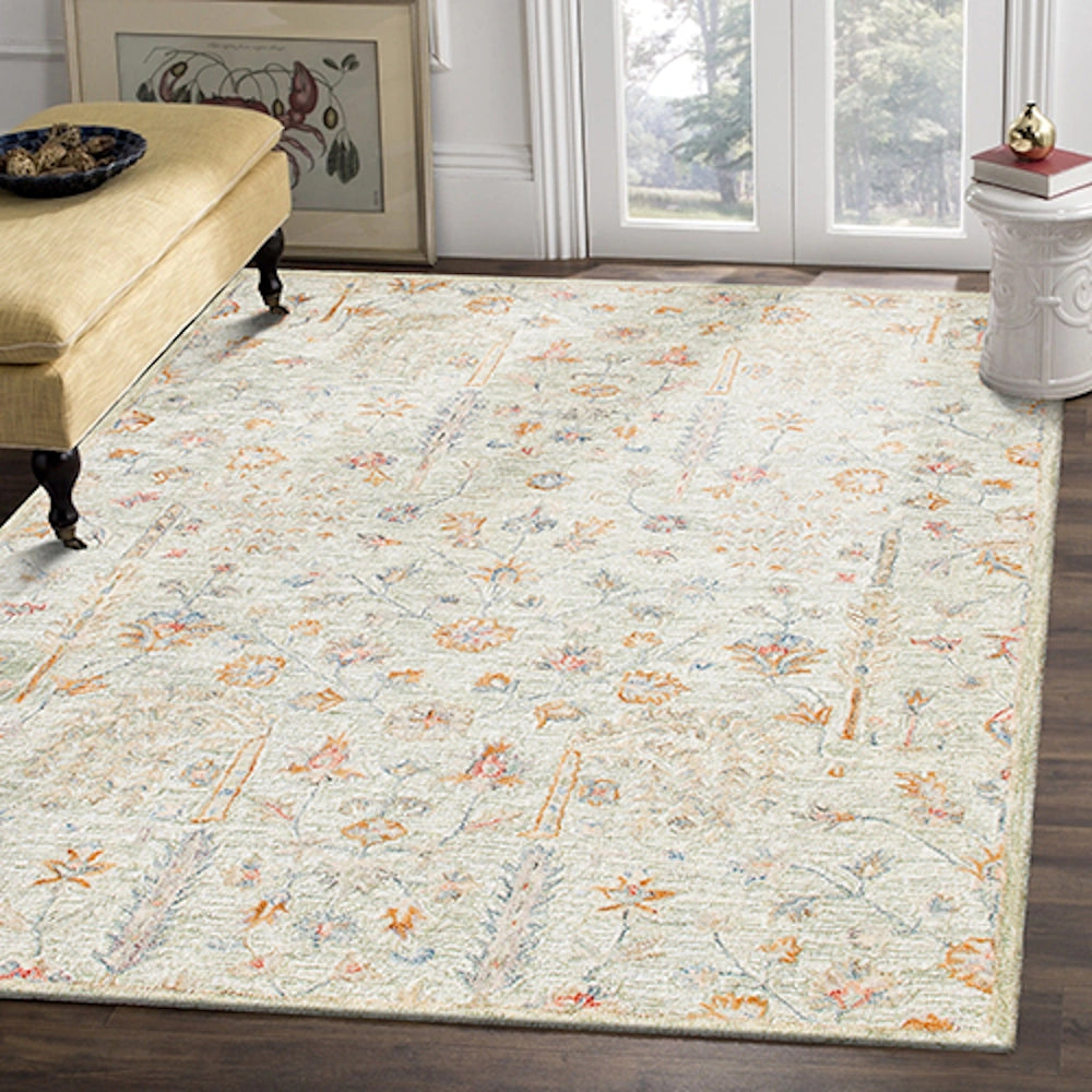 Hand-tufted rectangle vintage sage rug with floral patterns on a dark hardwood floor in a living room.