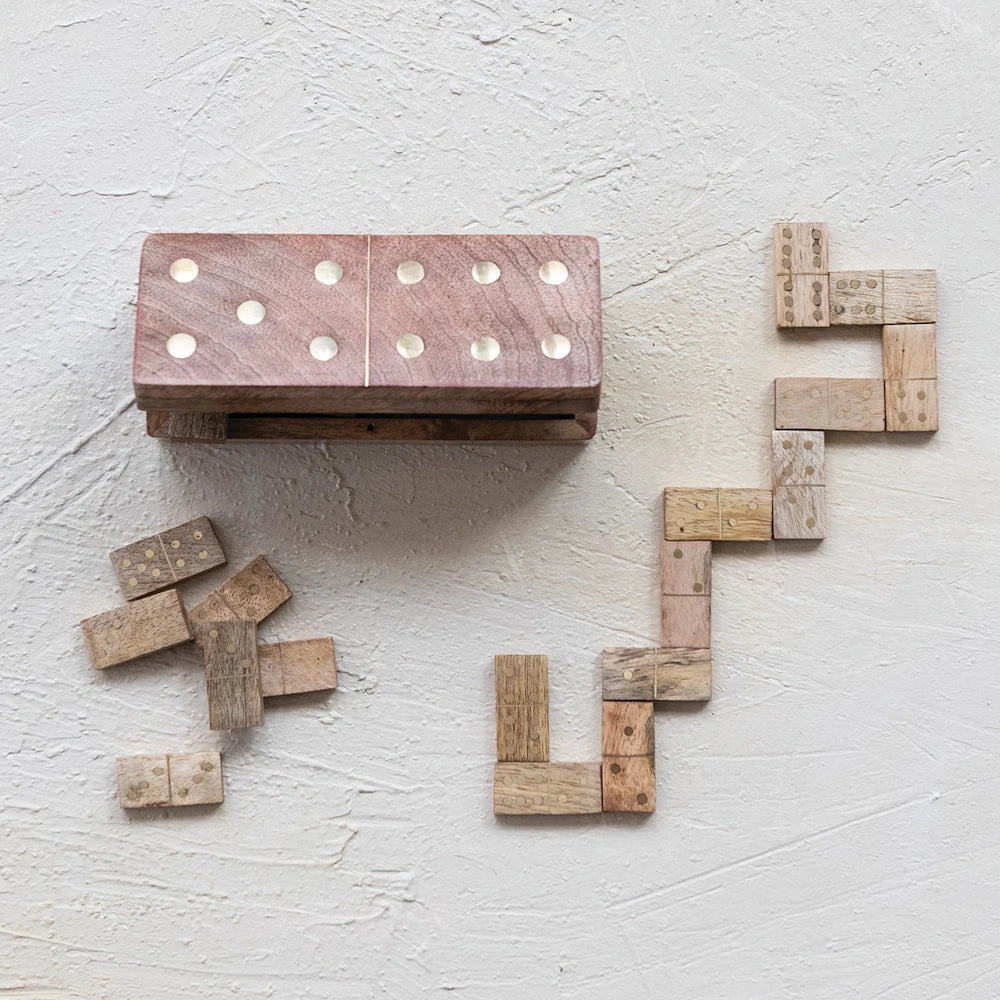 Handmade mango wood dominoes with brass inlays and matching wooden storage box on a textured white surface.