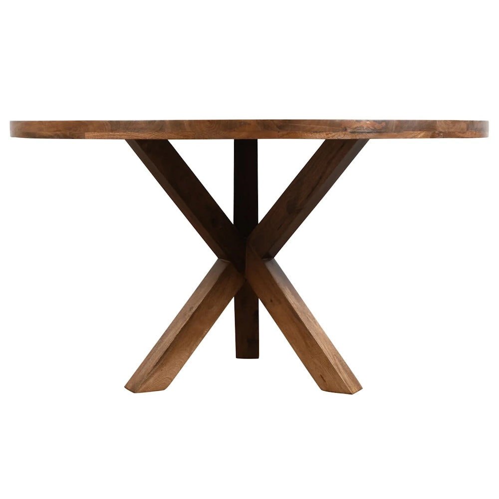 Side view of round natural wood dining table with thick tabletop and X shaped pedestal base.