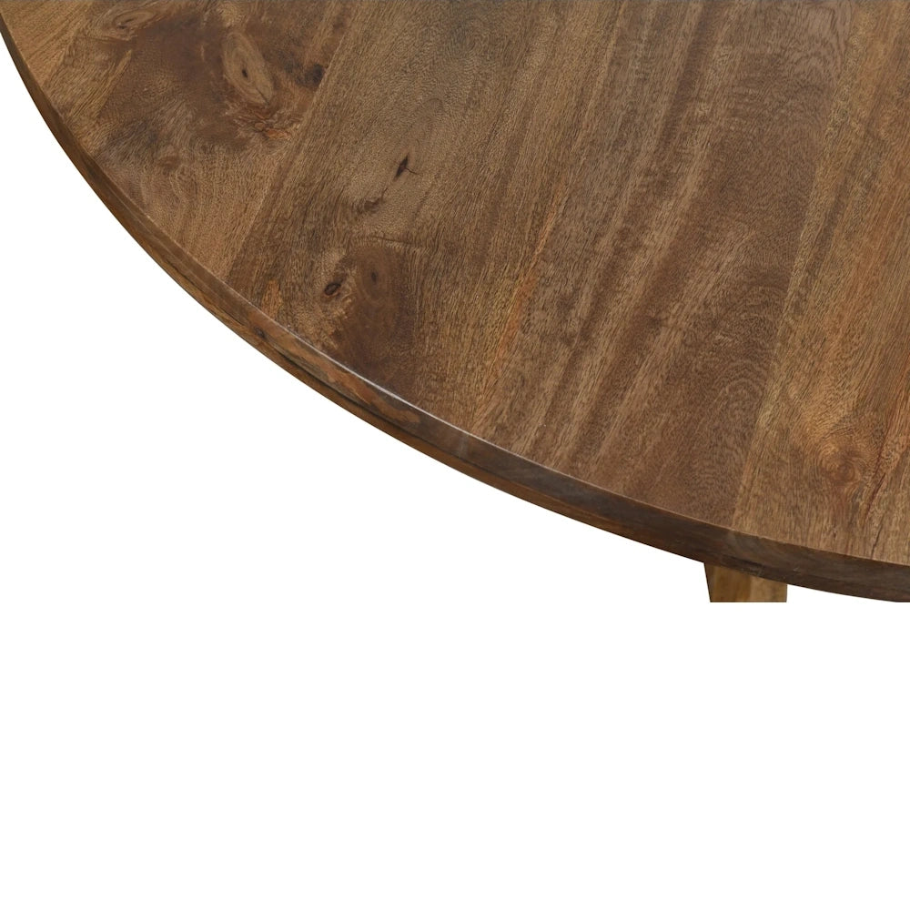 Close up of round natural wood dining table top showing thick beveled edge and rich grain detail.