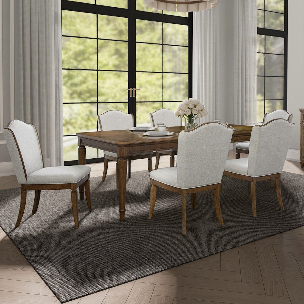 Traditional dark wood dining room set with upholstered chairs and dark woven rug.