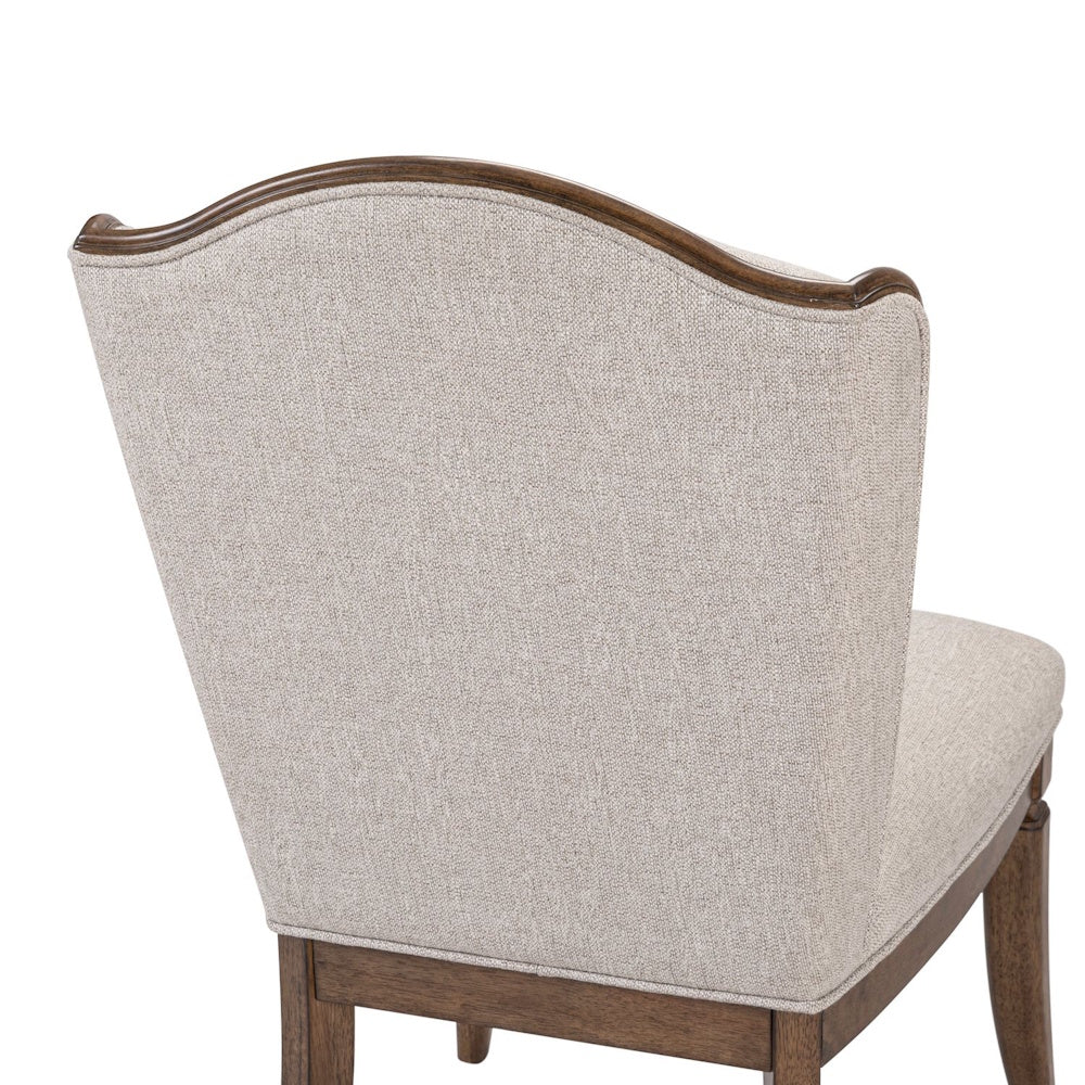 Close-up of the Harrison Heights upholstered side chair featuring a curved wood frame and textured light beige fabric.