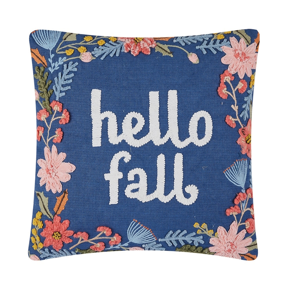 Blue pillow embroidered with "hello fall" in white text, surrounded by a border of colorful floral patterns.