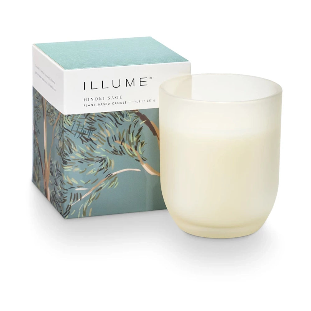 Illume Hinoki Sage plant-based candle in a frosted glass jar next to its decorative blue and green botanical box.