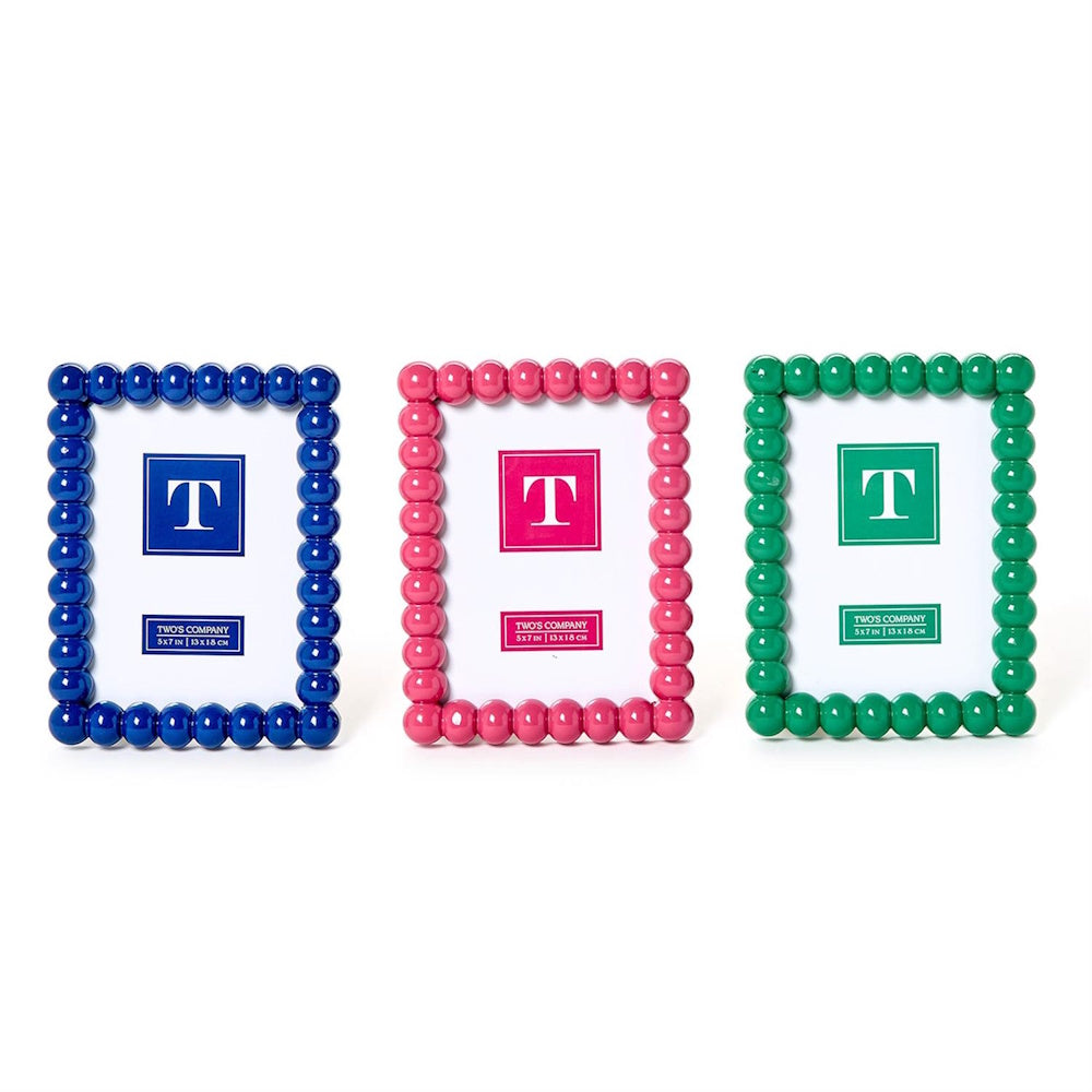 Three glossy hobnail photo frames in vibrant blue, pink, and green lined up on a white background.