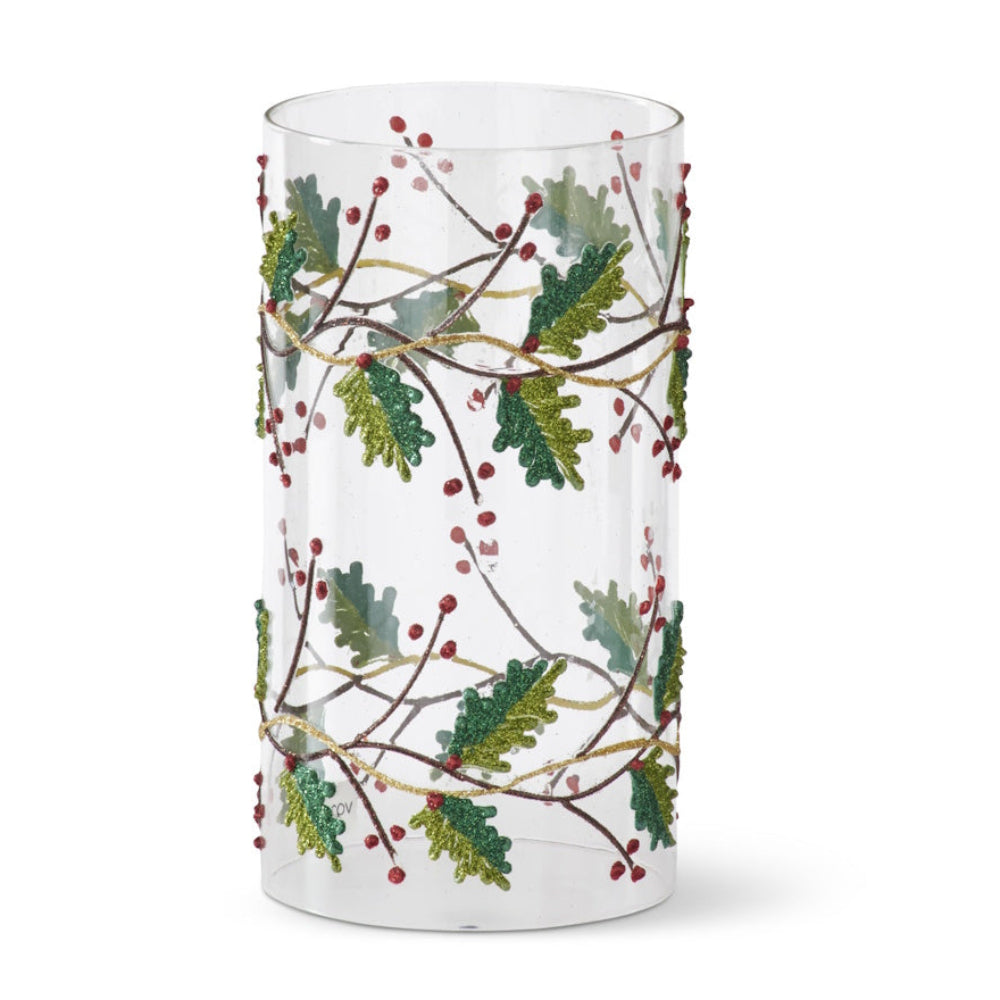 Clear glass cylinder sleeve decorated with glittery holly leaves, vines, and red berries.
