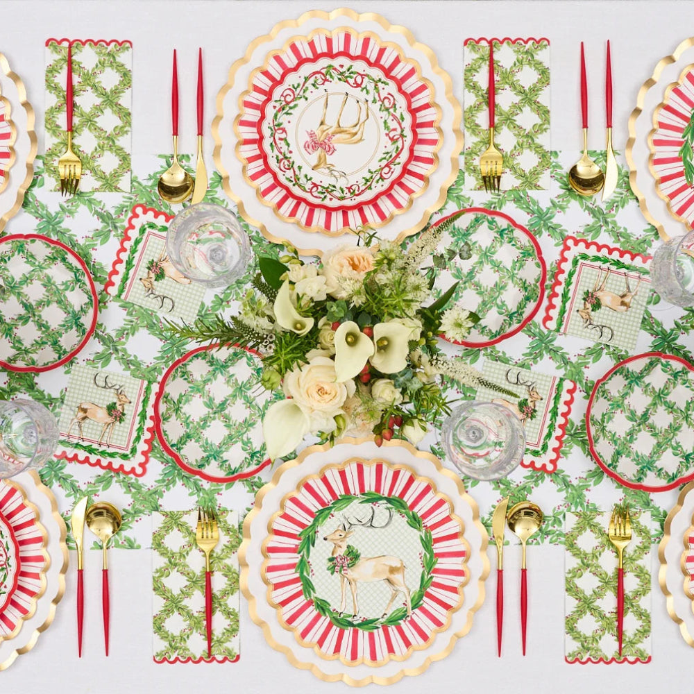 Overhead flat lay view of festive red, white, and gold paper dinner plates styled on a holiday table.