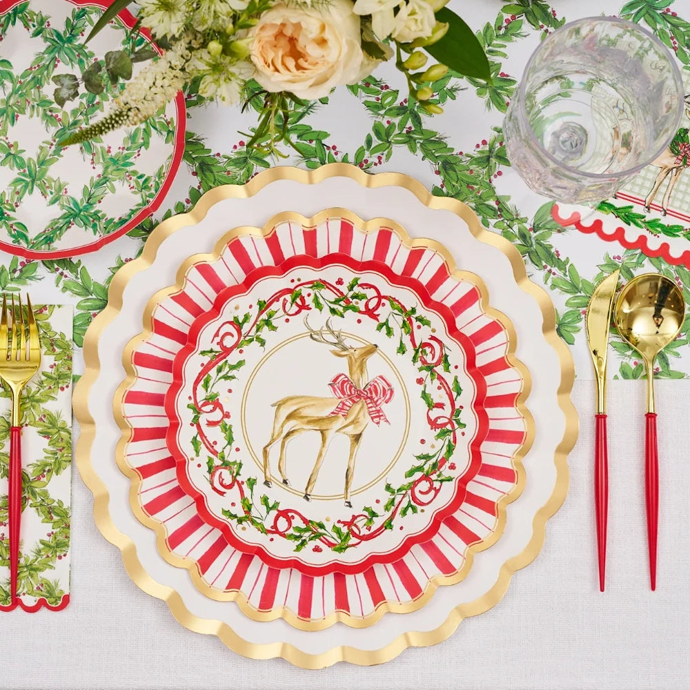 Flat lay view of red and white paper holiday salad plates styled in a festive table setting.