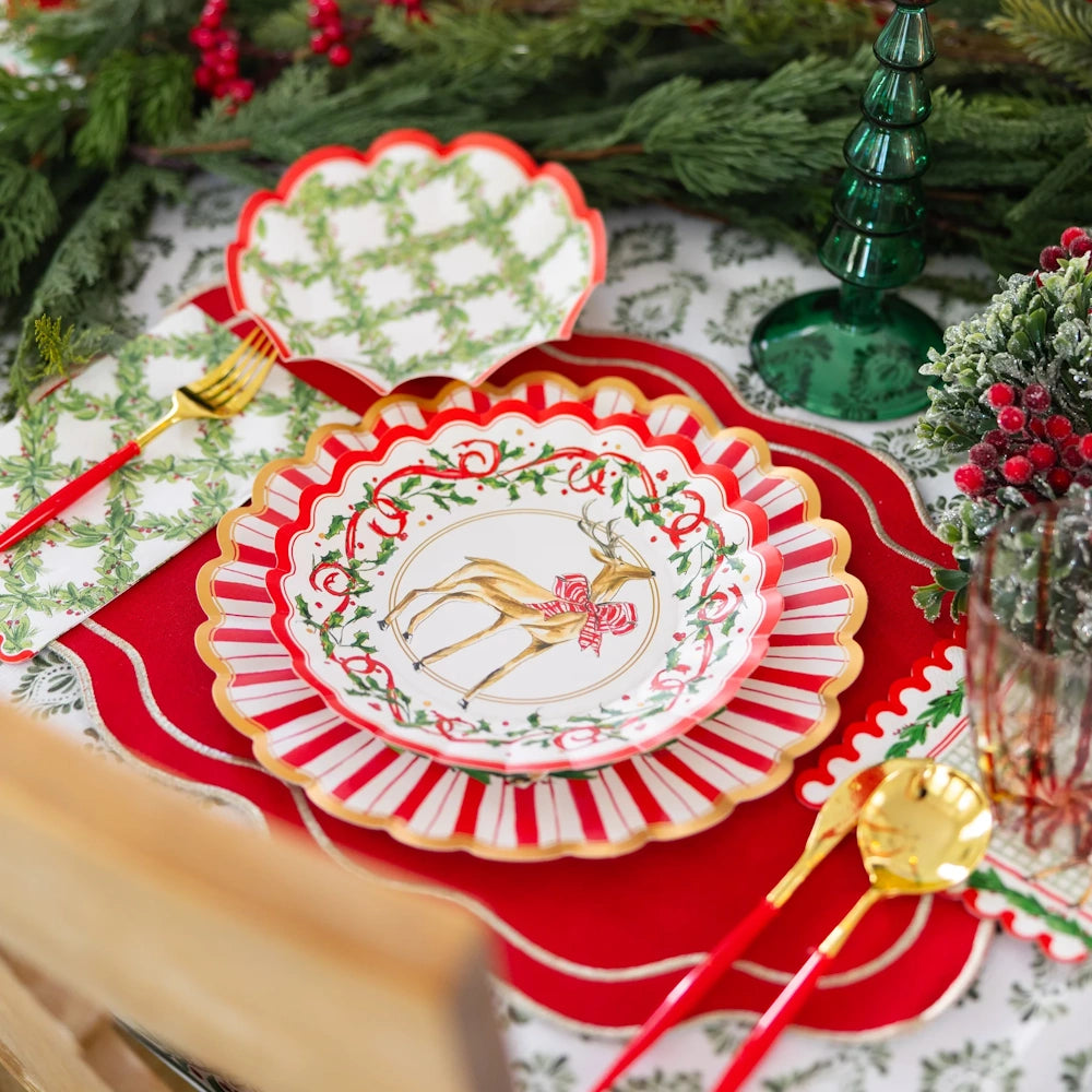 Angled view of red and white paper holiday salad plates styled in a festive table setting.