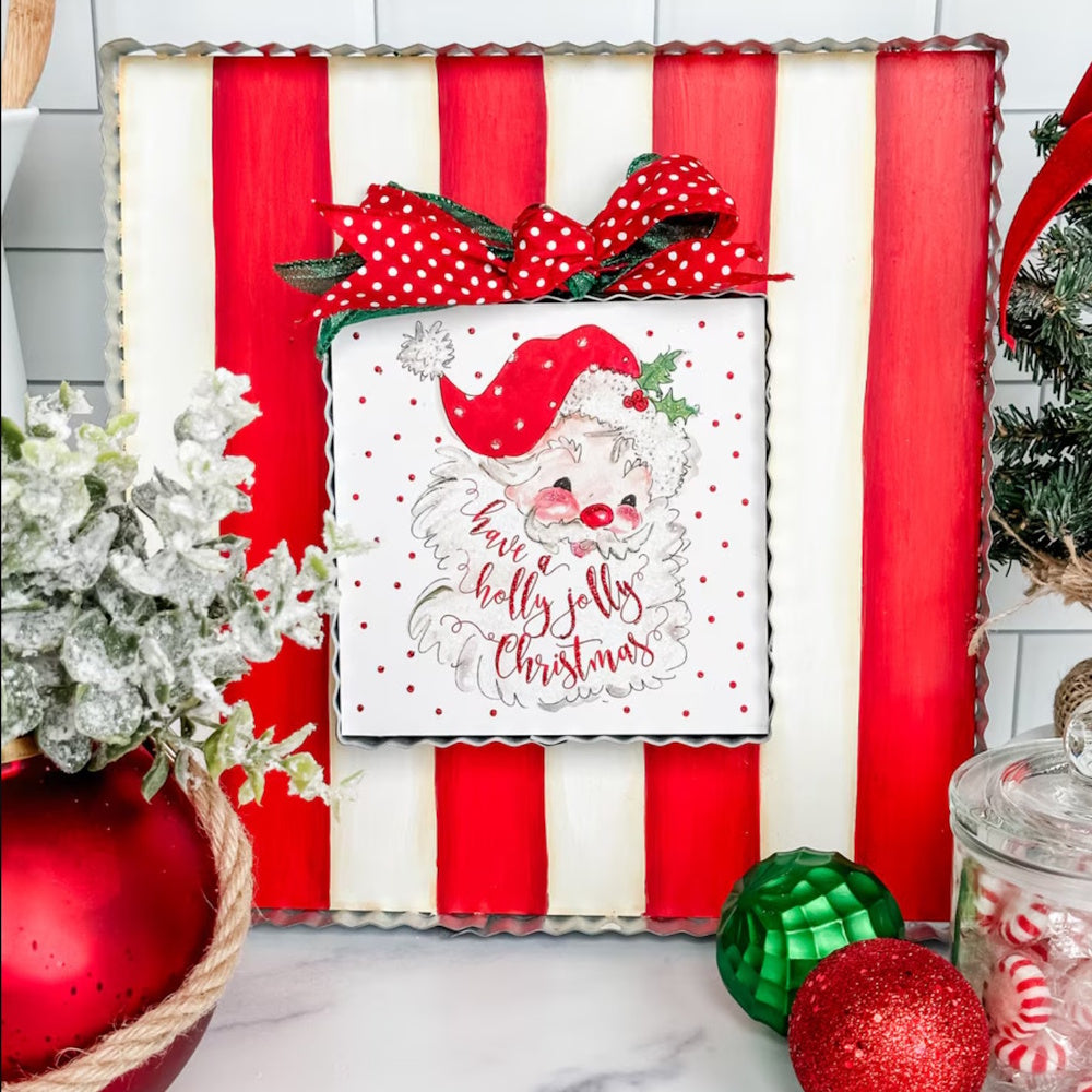 Front view of the red and white Santa art plaque featuring a painted metal design styled with holiday decor.