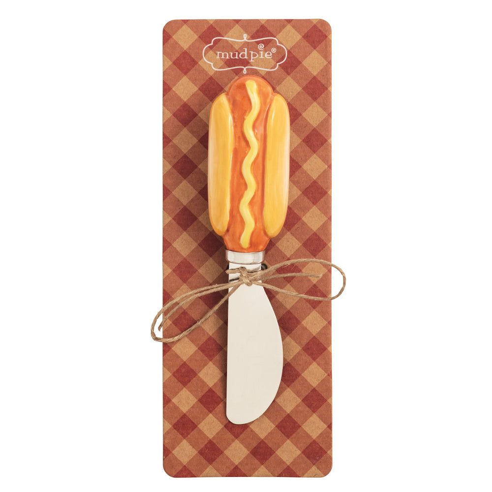Mud Pie hot dog ceramic handle cheese spreader on red gingham card, stainless steel blade for summer grilling parties.