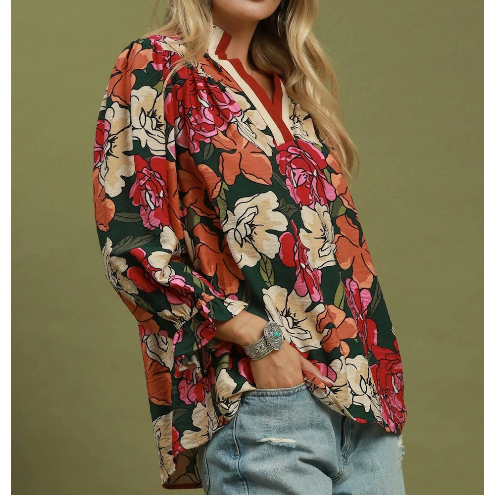Side view of a hunter green floral print cotton blouse with long sleeves and ruffled cuffs.