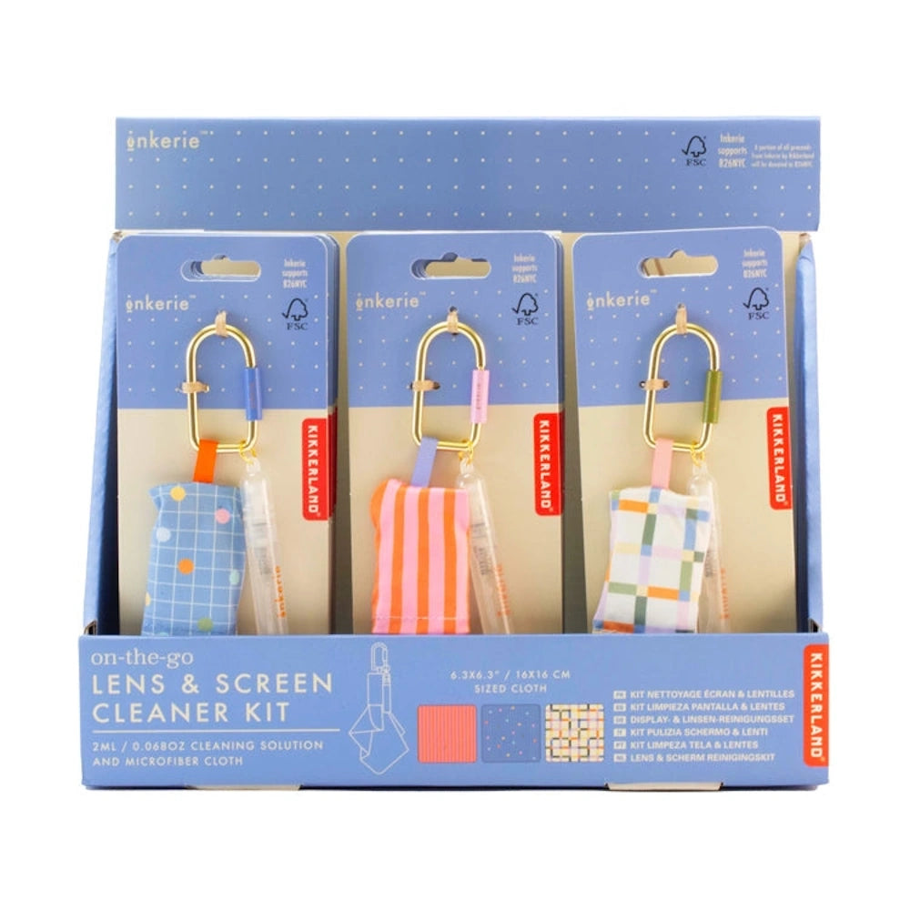 Retail display of Inkerie on-the-go lens and screen cleaner kits with various patterned cloths and spray bottles.