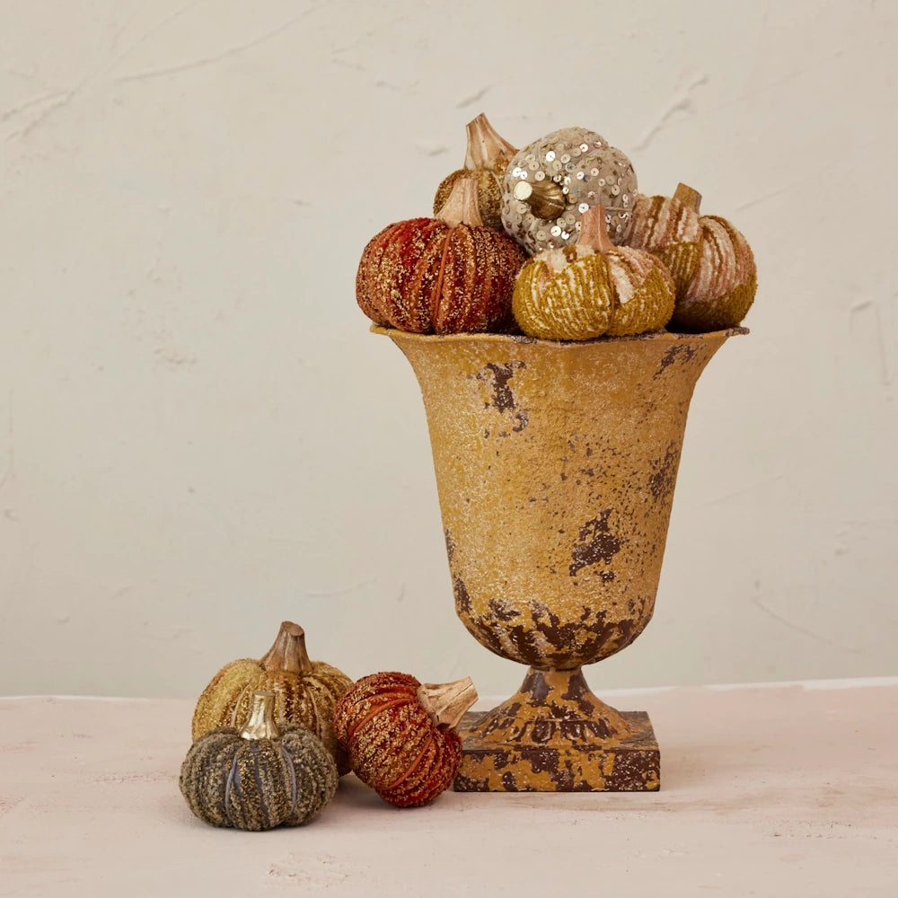 Antique sunflower yellow cast iron urn planter with a weathered, rustic finish on a square pedestal base.