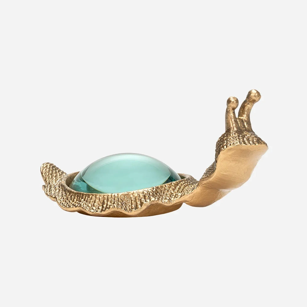 Brass snail figurine with a round glass magnifying lens embedded as its shell.