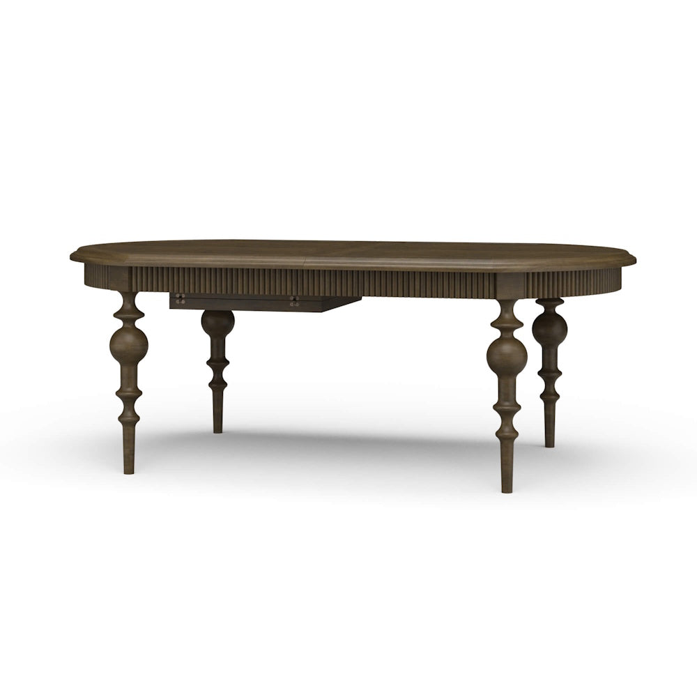 Oval wooden Kraton extension dining table with fluted apron and turned legs.