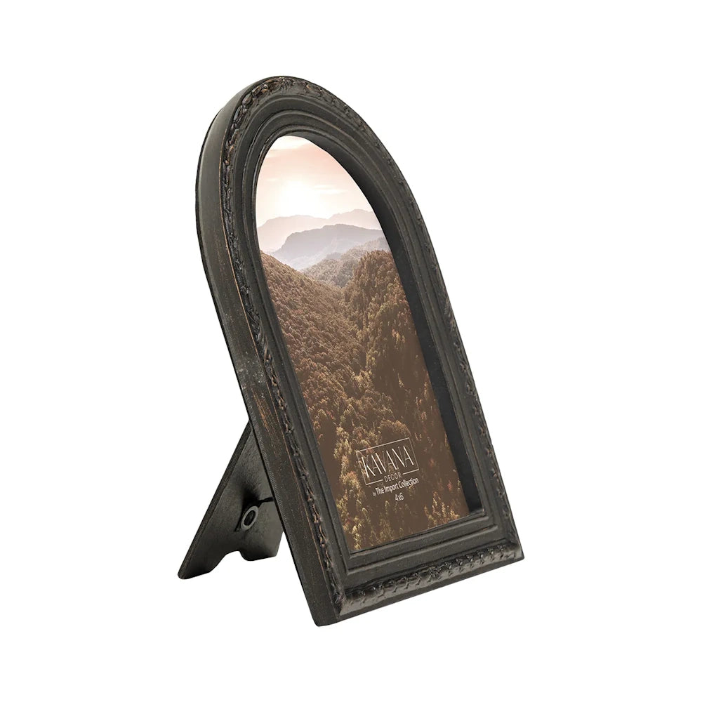 An arched, dark bronze picture frame with a beaded border, displaying a scenic photo of misty mountains.