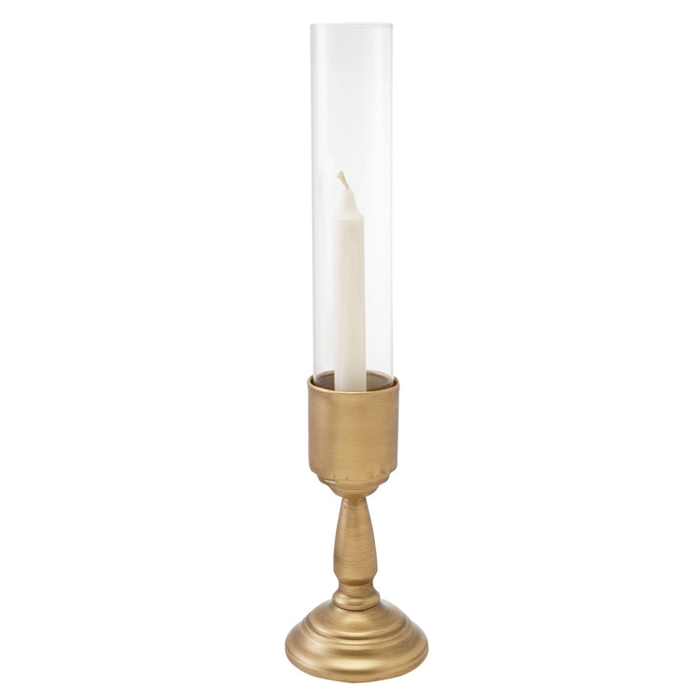 Gold metal taper candlestick holder with clear glass hurricane sleeve and white candle inside.