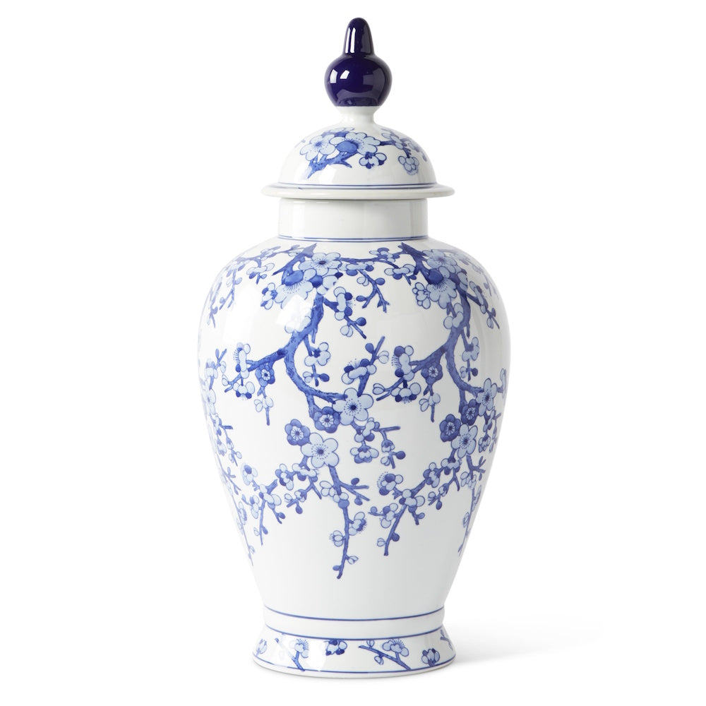 Blue and white chinoiserie ceramic ginger jar with lid and cherry blossom motif on a white background.