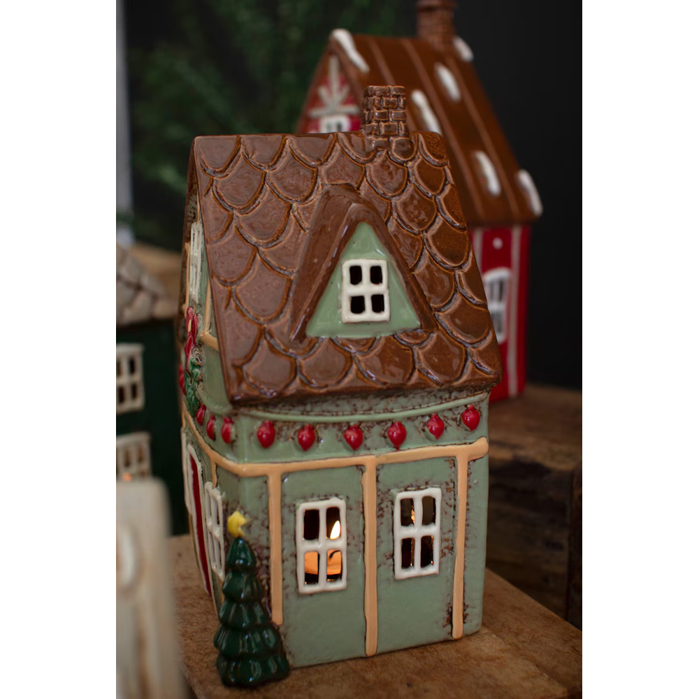Green ceramic Christmas village house with a brown tiled roof and festive holiday accents.