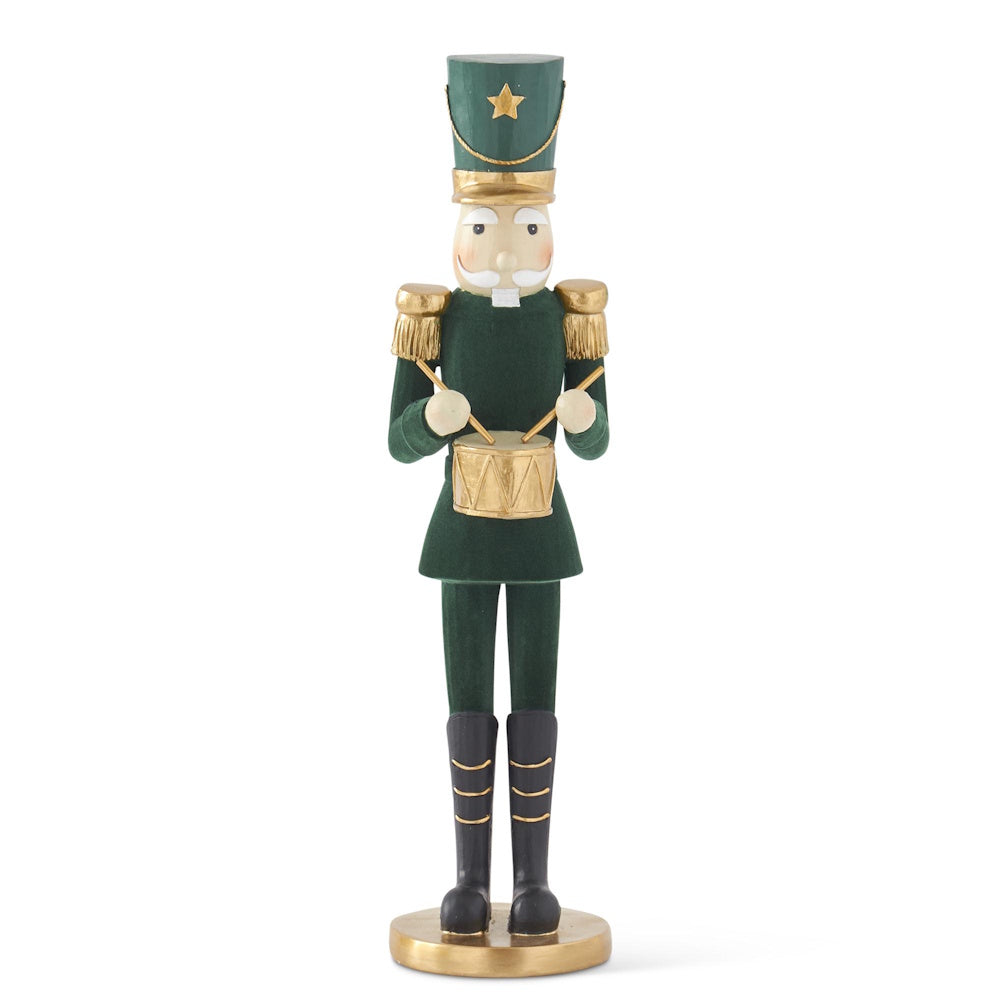 Front view of a tall dark green velvet nutcracker figurine in a gold-trimmed uniform playing a small drum.