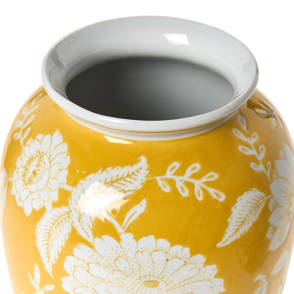 Top view of a yellow ceramic vase with a white-glazed interior and white floral patterns.