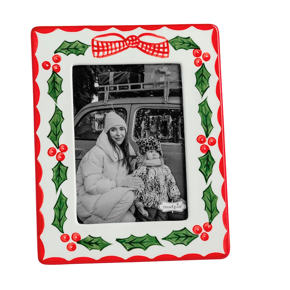White ceramic picture frame painted with red borders, green holly, red berries, and a plaid bow.