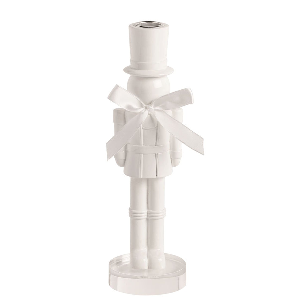 Large white lacquered nutcracker candlestick holder with a white satin bow on an acrylic base.