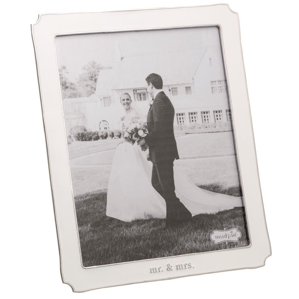 White enamel picture frame with "mr. & mrs." engraved at the bottom, holding a black and white wedding photo.