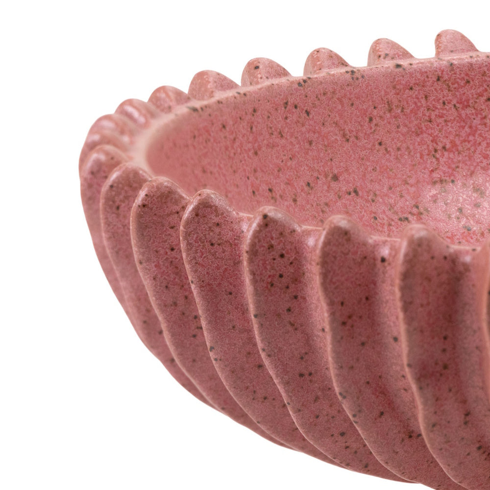 Close-up of a speckled pink ceramic bowl showing the detailed fluted, scalloped rim texture and matte finish.