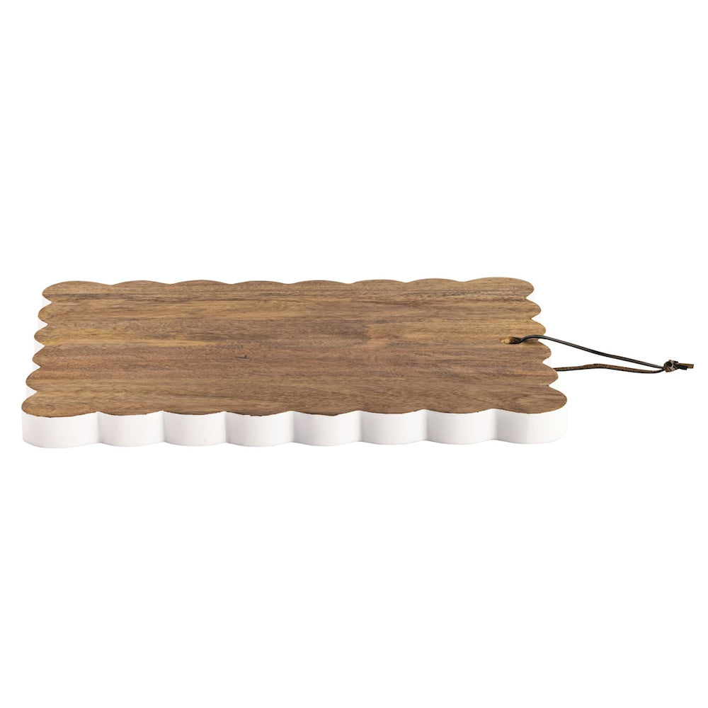 Large scalloped wood charcuterie board with white painted edges and a leather hanging loop for rustic kitchen decor.