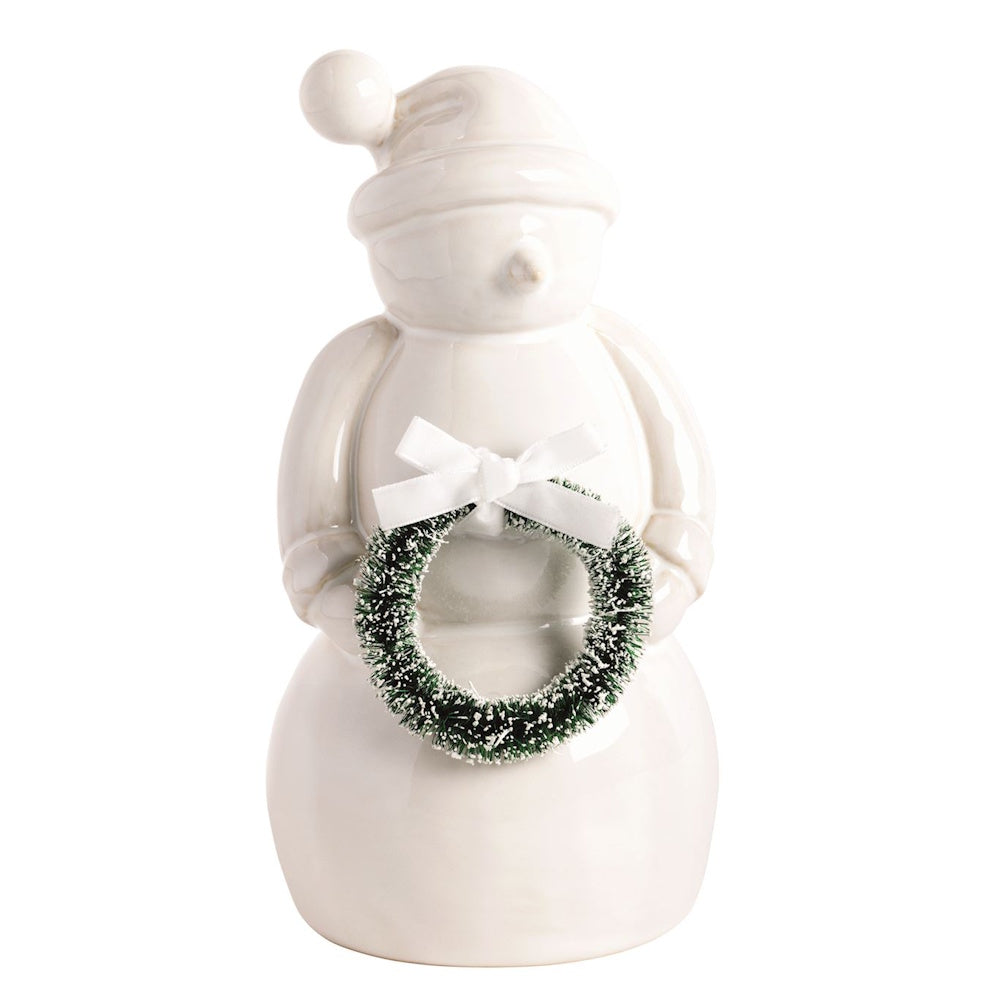 White ceramic snowman figurine holding a mini green wreath with a white bow.