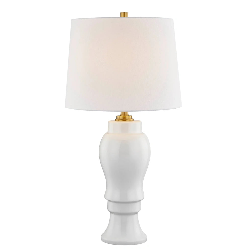 Elegant white ceramic table lamp with brass accents and a white drum shade for modern home decor.