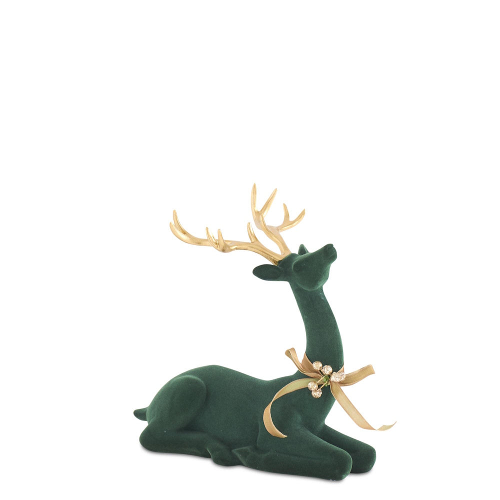 Front view of a laying dark green velvet deer figurine with gold antlers and a bow.