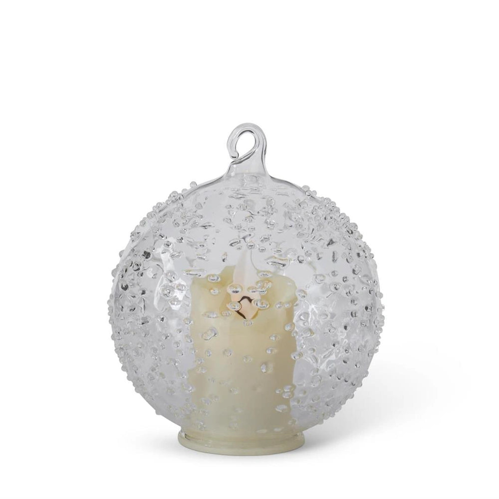 A textured clear glass round ornament featuring an internal LED candle and a top hanging loop.
