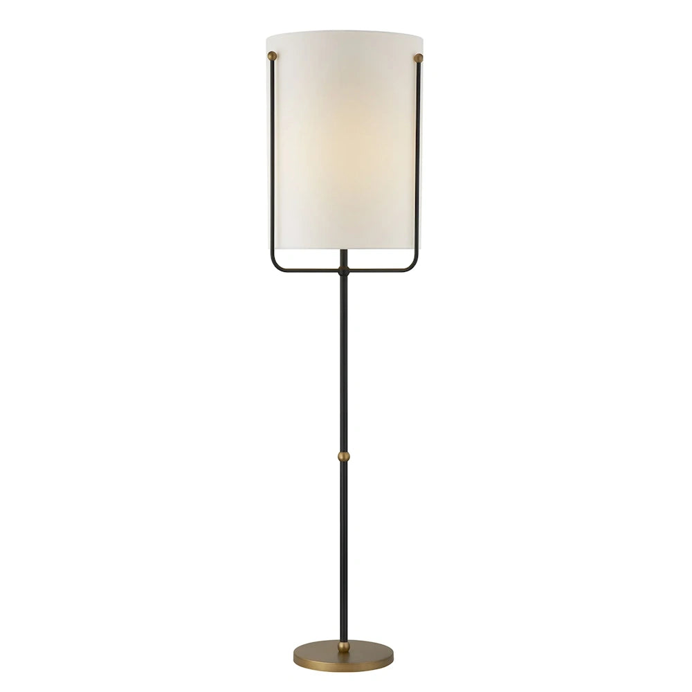 Modern floor lamp with black metal frame, brass accents and tall white cylindrical fabric shade.