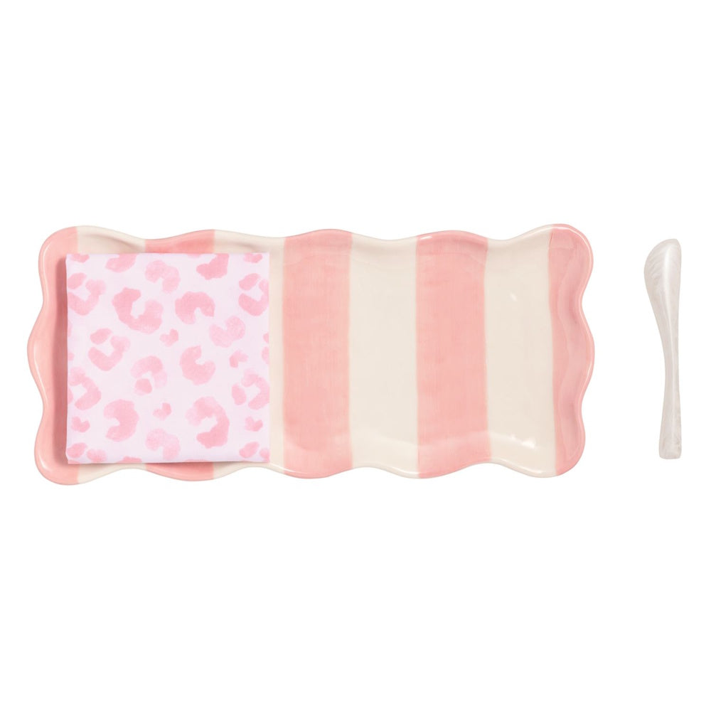 Pink and white striped ceramic serving tray with a pink leopard print napkin and a white spreading knife.