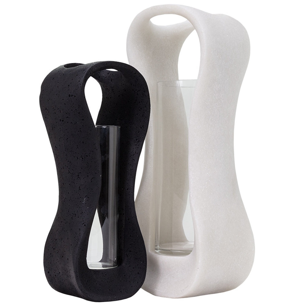 Modern black and white stone hurricane candle holders with curved sculptural frames and glass inserts.