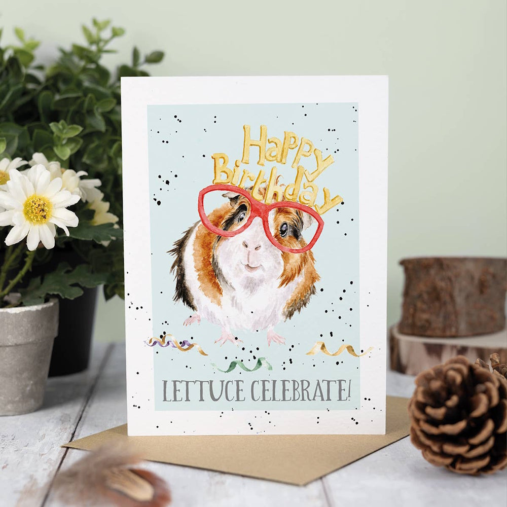 Watercolor guinea pig wearing red glasses and a "Happy Birthday" crown, with the punny text "LETTUCE CELEBRATE!"