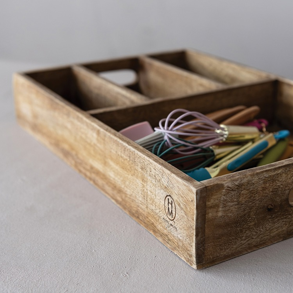 4-section mango wood tray with handles holding colorful kitchen utensils.