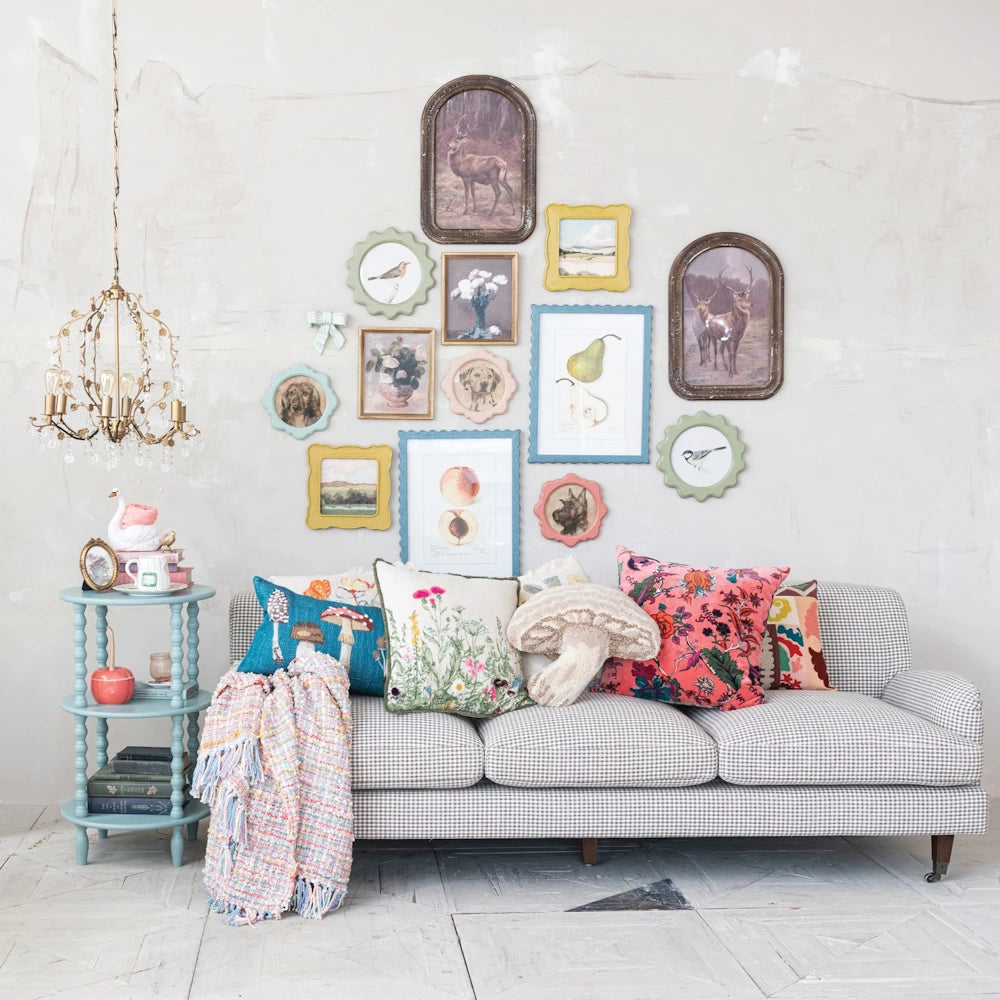Cottagecore living room featuring a checkered sofa, whimsical pillows, and an eclectic framed art gallery wall.