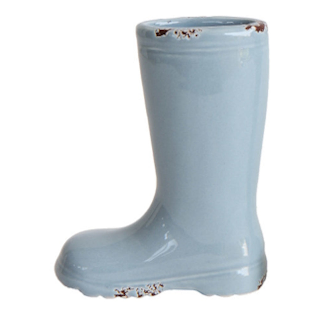 A light blue ceramic vase shaped like a rain boot with a glossy glaze and faux-distressed brown spots on the edges.