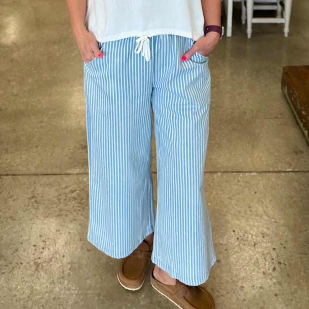 Light denim stone wash vertical stripe wide leg pants with white drawstring waistband and pockets.
