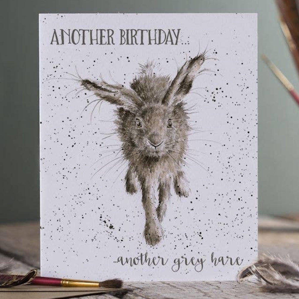 Illustration of a scruffy grey hare jumping with text: Another birthday... another grey hare.