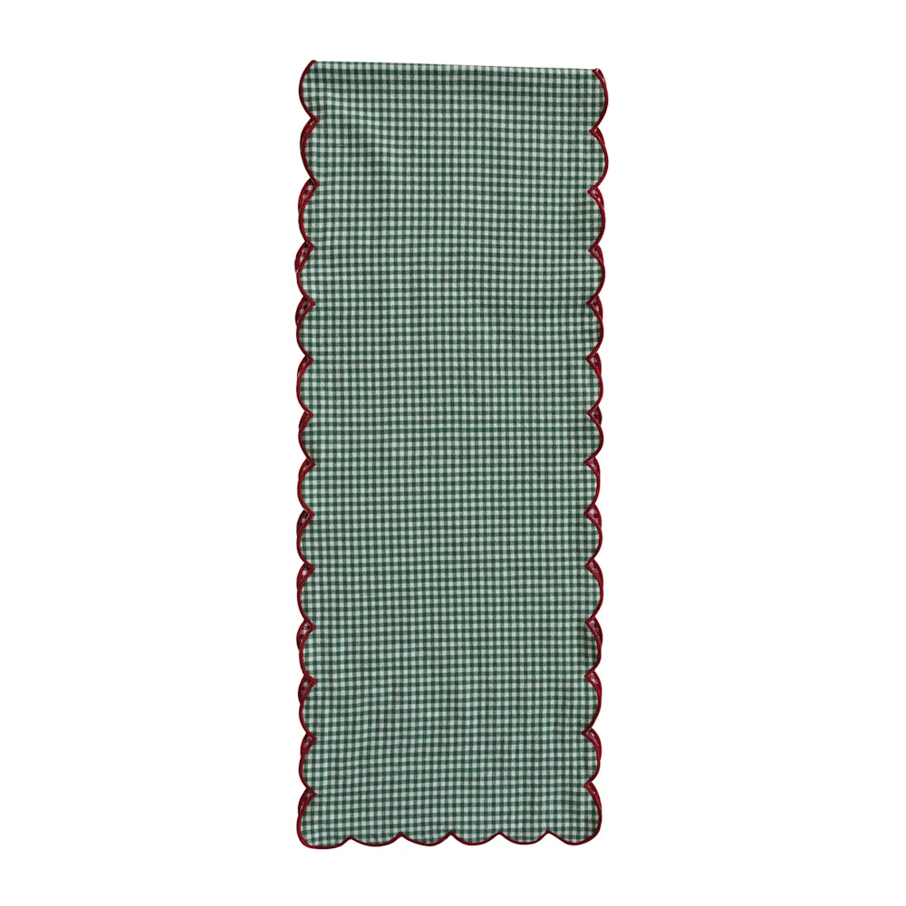 Long green and white gingham table runner featuring red scalloped edges against a clean white background.