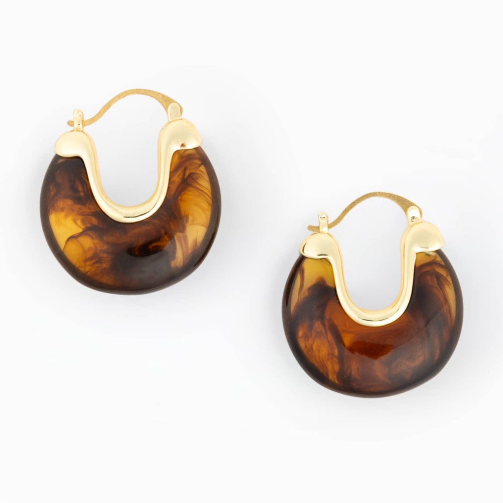 Pair of tortoiseshell resin hoop earrings with gold metal accents on a plain white background.